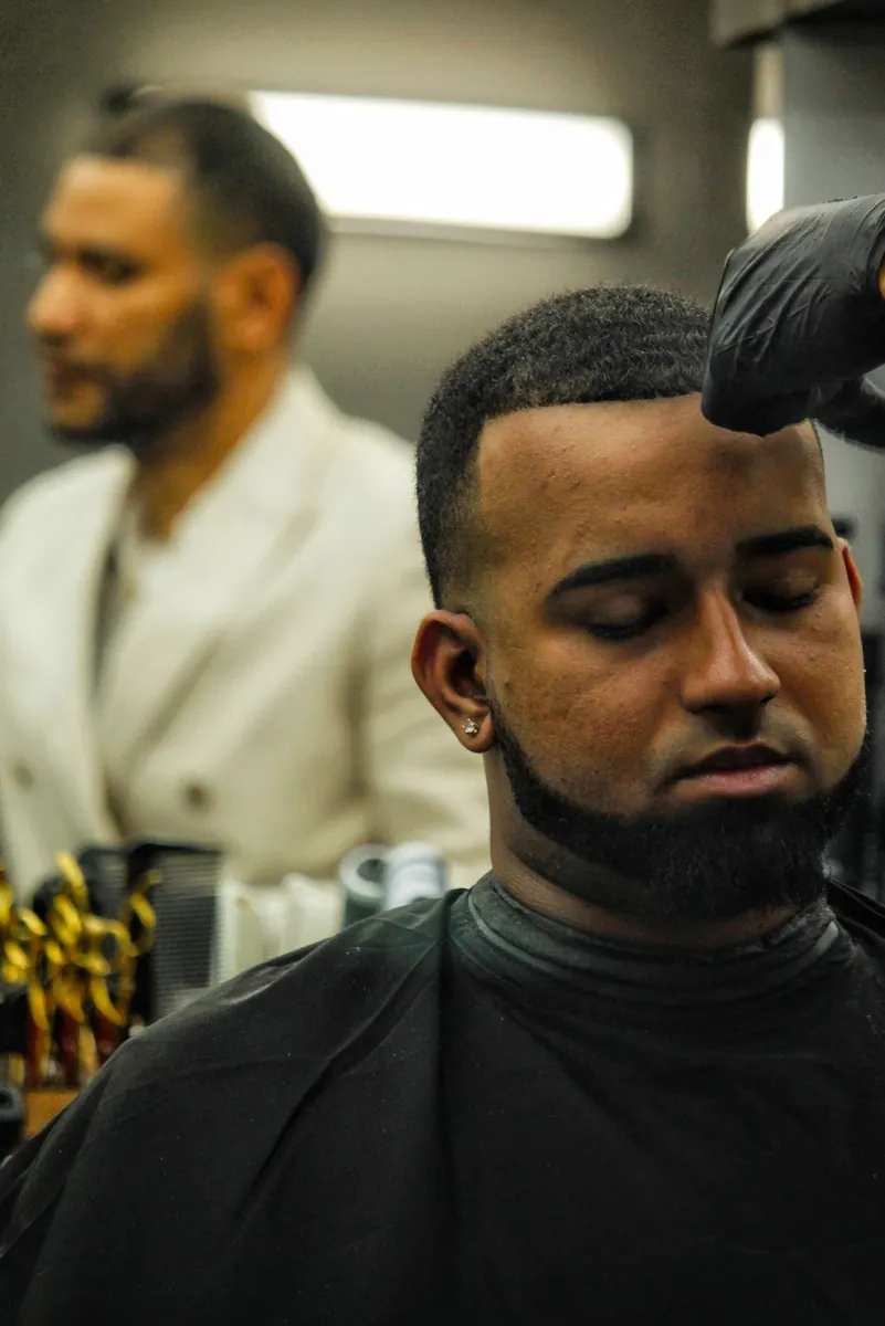A barber finishing a customer's beard