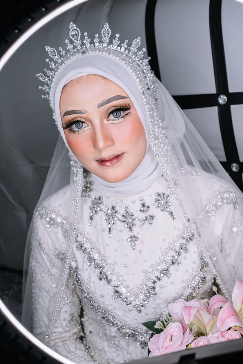A bride in a white hijab and veil after her makeup
