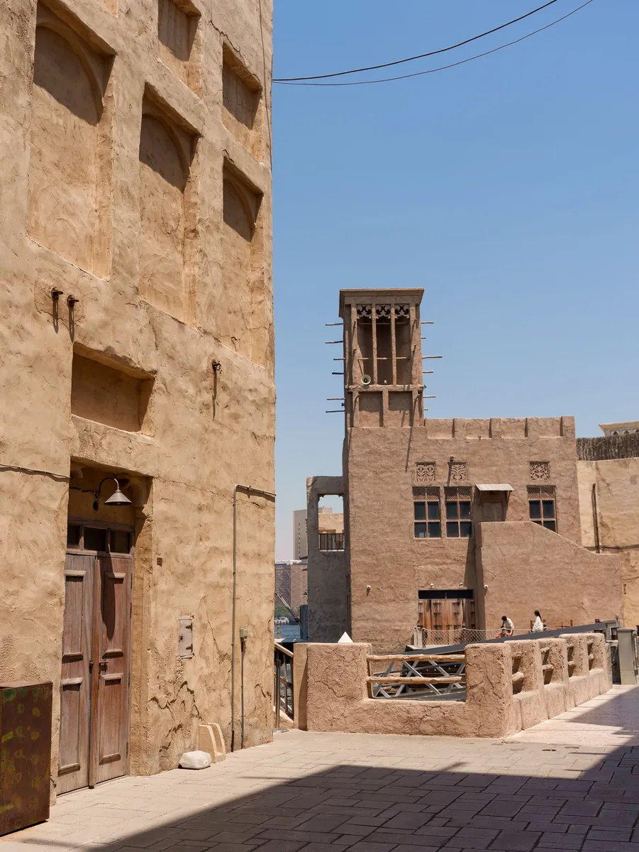 A wind tower rising over a lane in old Dubai